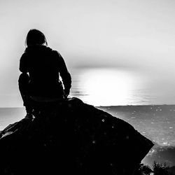 Rear view of woman standing on rocks