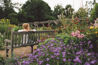 Young woman sitting on bench in park