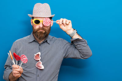 Portrait of man wearing hat against blue background