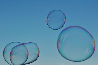 Close-up of bubbles against blue sky