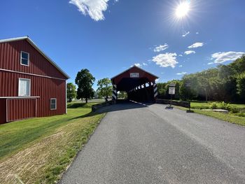 Road by building against sky on sunny day