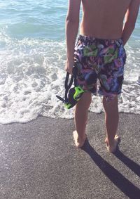 Low section of woman standing on beach