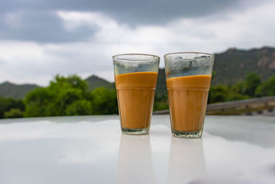 Hot tea filled in glasses at highway side from unique perspective at day