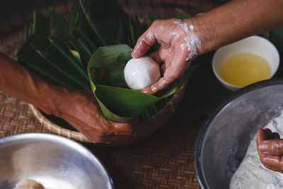 High angle view of woman putting rice cake in cone