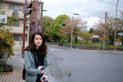 Portrait of beautiful young woman on road in city