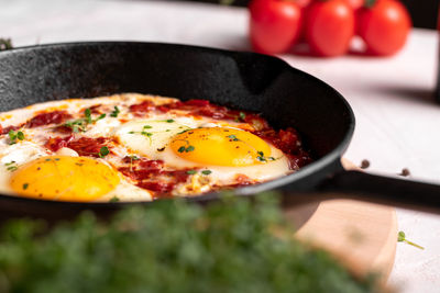 Traditional israel food eggs with tomatoes shakshouka in a pan close up