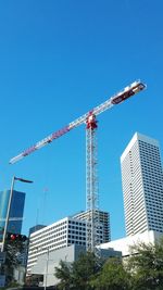 Low angle view of skyscraper against blue sky