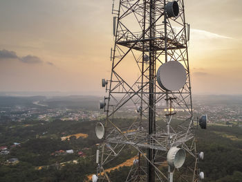 Communications tower against sky during sunset