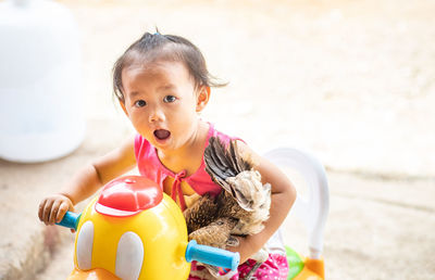 Portrait of cute baby girl with toy on beach