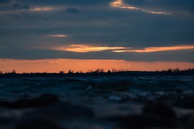 Scenic view of sea against dramatic sky during sunset