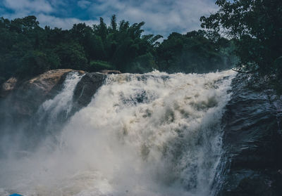 Scenic view of waterfall against sky