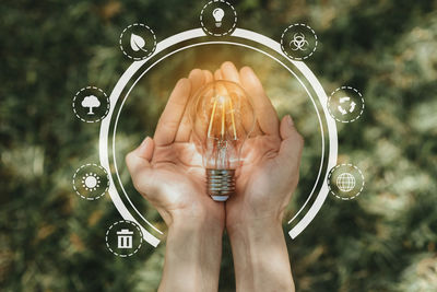 Close-up of hand holding light bulb