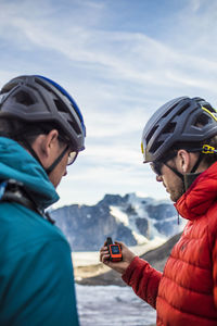 Two explorers use a gps to navigate mountain terrain.