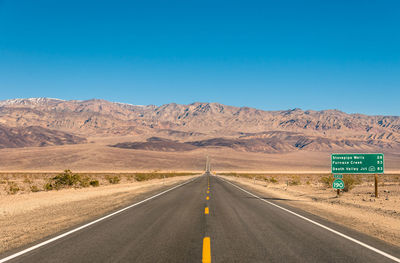 Road sign against clear blue sky