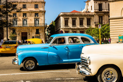 Vintage car on street against buildings in city