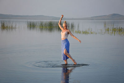 Full length of woman standing in lake