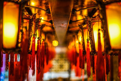 Illuminated light bulbs hanging from ceiling of building