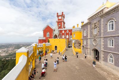 Tourists at palacio da pena against sky