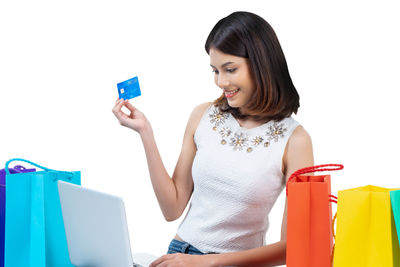 Young woman using mobile phone against white background