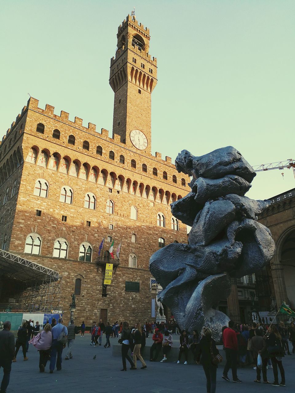 architecture, built structure, building exterior, history, large group of people, sculpture, statue, travel destinations, clear sky, day, real people, men, low angle view, outdoors, women, city, sky, people