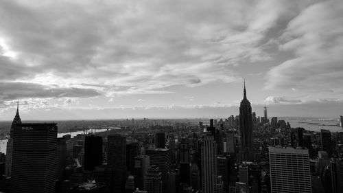 View of cityscape against cloudy sky