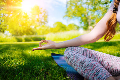 Side view of woman sitting on field