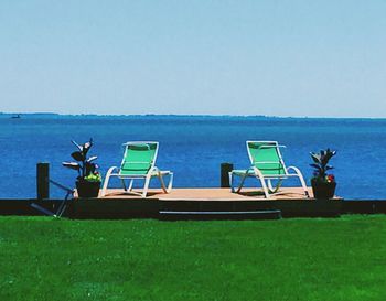 Empty chairs in calm sea