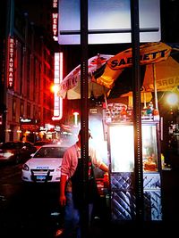 Woman in illuminated city at night