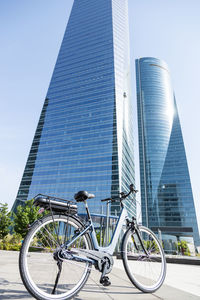 Contemporary blue bike parked on paved street in city center on sunny day