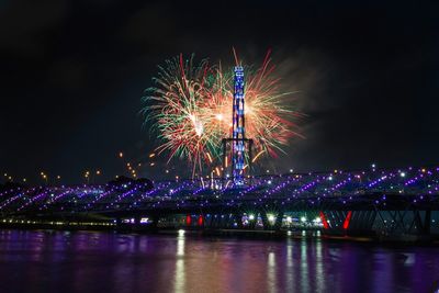 Firework display over river at night