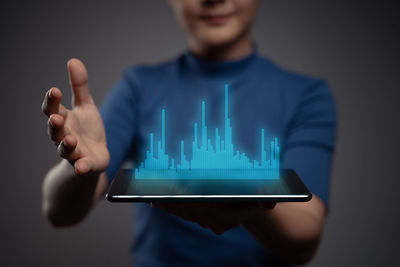 Midsection of man using smart phone against black background