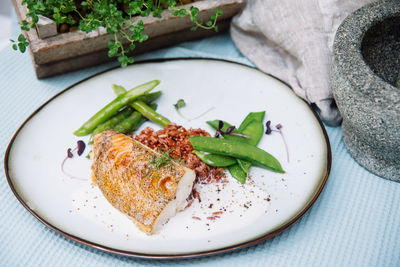 Halibut white fish fillet with ruby rice in coconut sauce and blanched asparagus