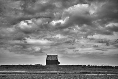 View of field against cloudy sky