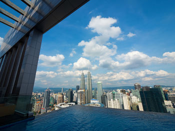 City at waterfront against cloudy sky