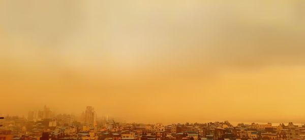 Buildings in city against sky during sunset