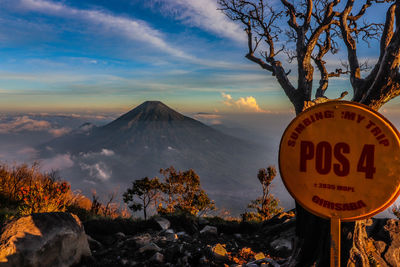 Information sign on mountain against sky during sunset