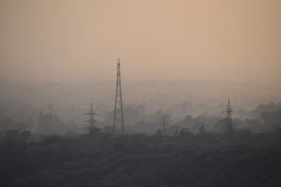 Electricity pylon against sky during sunset