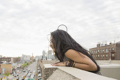 Young woman leaning on a bridge in queens, new york