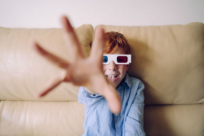 Portrait of boy smiling on sofa at home