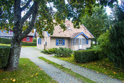 Houses by trees against sky