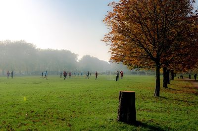 People on field in park against sky during autumn