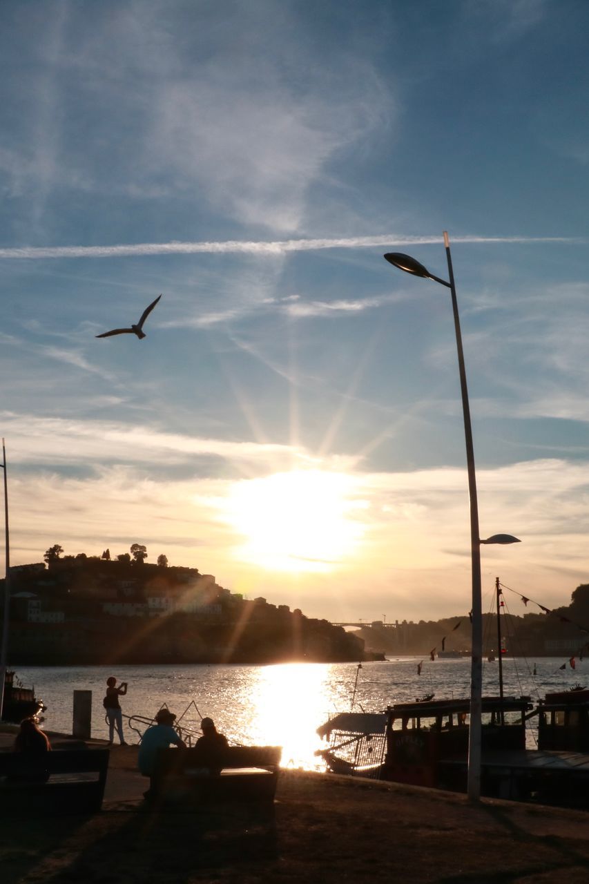 SILHOUETTE BIRDS FLYING OVER SEA AGAINST SKY