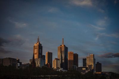 View of skyscrapers against cloudy sky