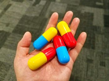 Close-up of hand holding multi colored pencils