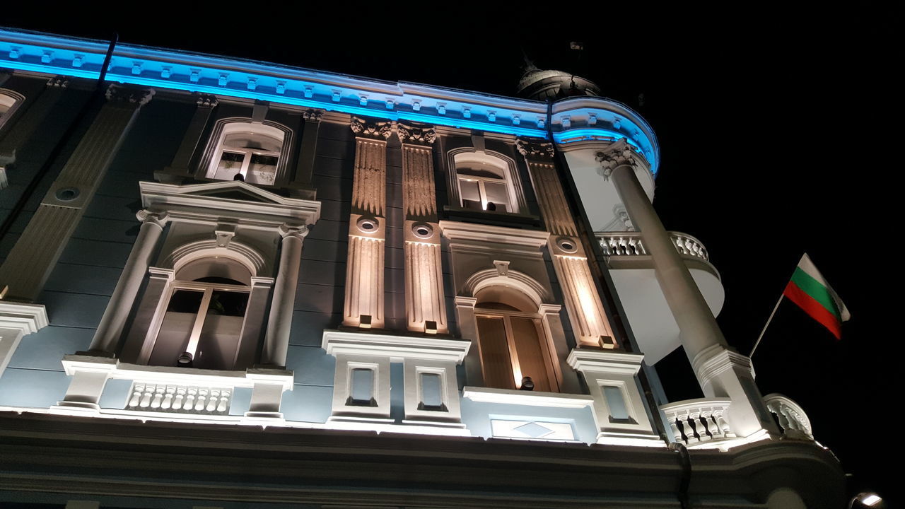 LOW ANGLE VIEW OF ILLUMINATED BUILDING AGAINST SKY AT NIGHT