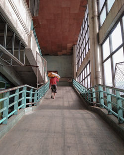 Rear view of man walking on building