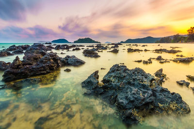 Rocky shore and sea against sky 