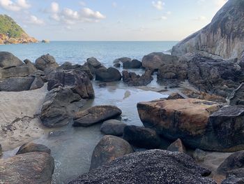 Rocks on sea shore against sky