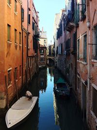 Canal amidst city against sky