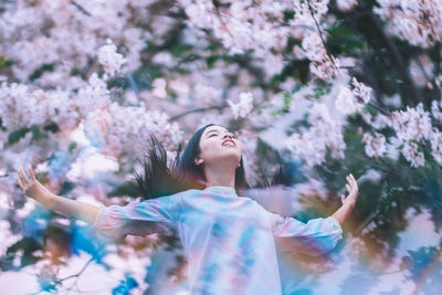 Woman with arms raised on flowers